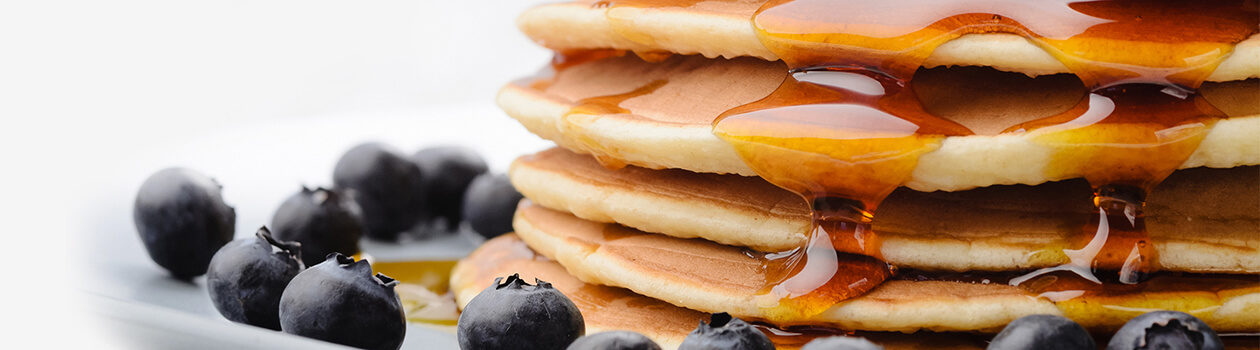 Picture of some tempting pancakes with some berries on the side.